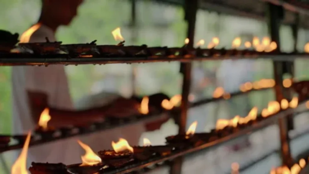 Devotees visiting a Buddhist temple with oil lamps